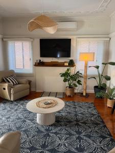 a living room with a couch and a table at Darlow Cottage in Wagga Wagga