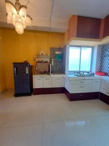a large kitchen with white cabinets and a chandelier at Siddhi Home Stay in Kolhapur