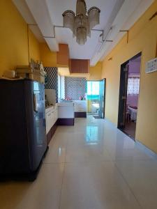 a large kitchen with a refrigerator and a table at Siddhi Home Stay in Kolhapur +3 photos