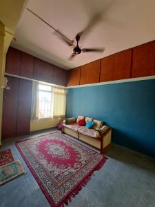 a living room with a couch and a ceiling fan at Siddhi Home Stay in Kolhapur