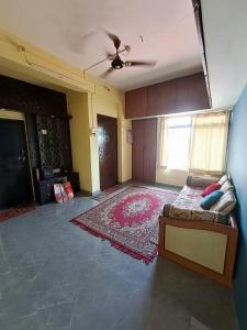 an empty living room with a bed and a rug at Siddhi Home Stay in Kolhapur