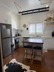 a kitchen with a counter and two stools at Darlow Cottage in Wagga Wagga +9 photos