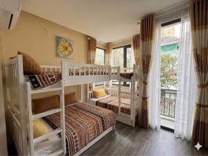 a bedroom with two bunk beds and a balcony at The New Chapter Hostel in Ho Chi Minh City