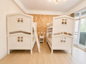 two white bunk beds in a room with a window at Songfeng B&B in Luye +5 photos
