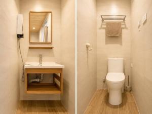 a bathroom with a toilet and a sink and a mirror at Songfeng B&B in Luye