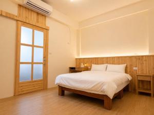a bedroom with a large bed and a window at Songfeng B&B in Luye