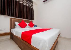 a bedroom with a large bed with red pillows at Hotel Cliff Hanger in Mumbai +4 photos