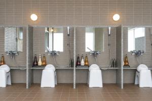 a bathroom with a bunch of sinks and mirrors at Rembrandt Resort Shiretoko in Shari