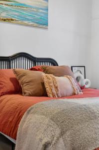 a bed with pillows and a painting on the wall at Styled Entertainer only mins from CBD in Bendigo