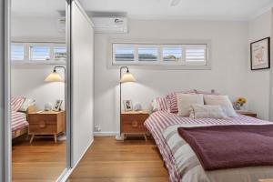 a white bedroom with a bed and two windows at Styled Entertainer only mins from CBD in Bendigo