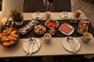 a table with plates of breakfast foods and utensils at TRIP Hotel in Toshkent-Passajir Bekati