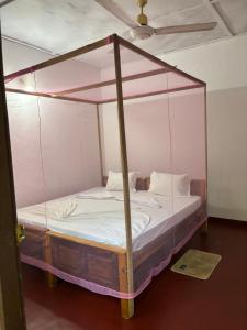 a bed with a canopy in a room at Lime pepper in Pottuvil
