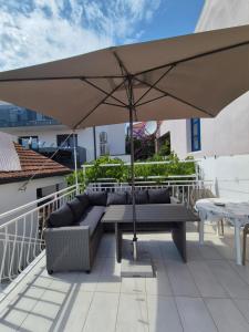 a patio with a table and an umbrella at Šućur holiday home in Preko