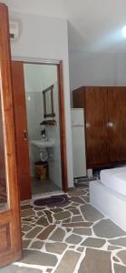 a room with a bathroom with a mirror and a sink at Arleta's Sunny Guesthouse in Prinos