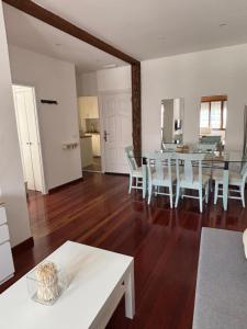 a dining room and living room with a table and chairs at Apartamento Arena in Ribadesella