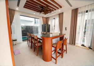 a dining room with a table with chairs and a television at Villa The Pearl -Vlasta Sầm Sơn in Sầm Sơn