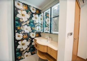 a bathroom with a sink and flowers on the wall at Villa The Pearl -Vlasta Sầm Sơn in Sầm Sơn +32 photos