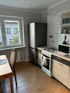 a kitchen with a stove and a refrigerator and a table at Wygodny kąt in Tarnobrzeg