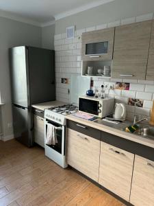 a kitchen with a stove and a refrigerator at Wygodny kąt in Tarnobrzeg