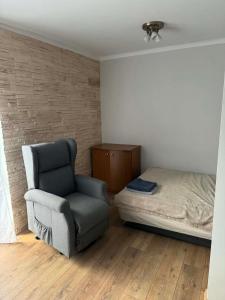 a bedroom with a chair and a bed at Wygodny kąt in Tarnobrzeg