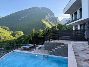 a house with a swimming pool with mountains in the background at Villa Luxury Forest in Peje