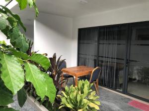a wooden table and chairs in a room with plants at Zukara Maldives in Thoddoo