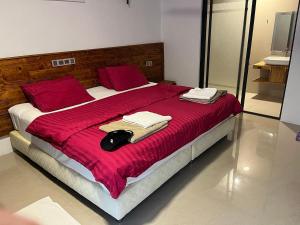 a bedroom with a large bed with red sheets and red pillows at Zukara Maldives in Thoddoo
