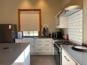a kitchen with white cabinets and a stove top oven at River and Ridge in Cradock