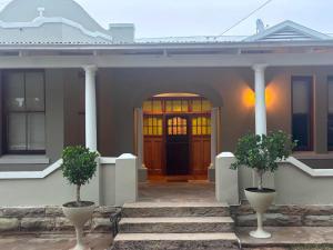 a front door of a house with two potted trees at River and Ridge in Cradock