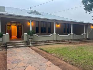 a white house with a pathway in front of it at River and Ridge in Cradock