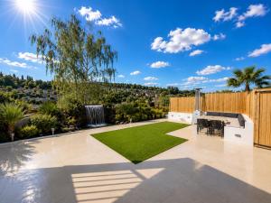 a backyard with a lawn and a fence at Luxurious & Elegant 6-Bed House in Barnet