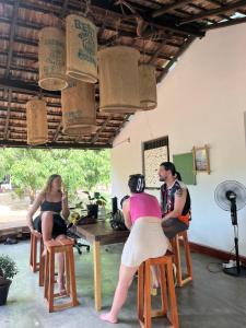 a group of people sitting at a table at Waves & Paws Hostel in Arugam Bay