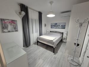 a small bedroom with a bed and a window at Šućur holiday home in Preko