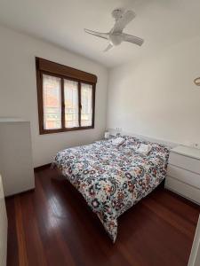 a bedroom with a bed with a floral bedspread at Apartamento Arena in Ribadesella