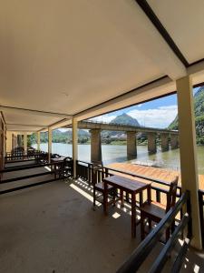 a deck with benches and a view of a bridge at Views Backpackers Hostel in Nongkhiaw