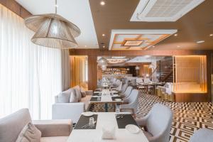 a restaurant with couches and tables and chairs at Royal Ritis in Shimoga