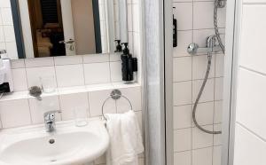 a bathroom with a sink and a shower at DORMERO Hotel Werther in Werther