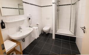 a bathroom with a sink and a toilet and a shower at DORMERO Hotel Werther in Werther