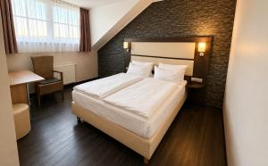 a hotel room with a bed and a desk at DORMERO Hotel Werther in Werther +9 photos