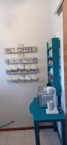 a blue table with a hot coffee sign on a wall at Arleta's Sunny Guesthouse in Prinos +41 photos