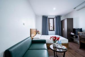 a living room with a couch and a bed at Granda Hanoi Hotel & Apartment in Hanoi