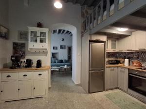 a kitchen with white cabinets and a stainless steel refrigerator at Traditional house in the heart of Naxos in Dhamariónas