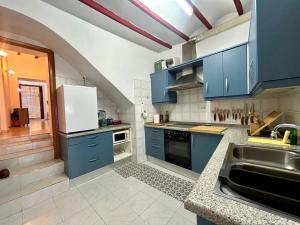 a kitchen with blue cabinets and a sink at Casa De Pueblo Raval in Teulada