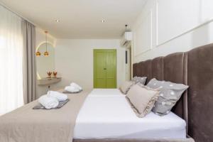 a large white bed with pillows and a green door at Apartments Dare & Piccolo in Kaštela +117 photos