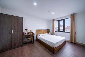 a bedroom with a bed and a desk and a window at Granda Hanoi Hotel & Apartment in Hanoi