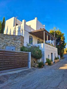 a white house with a fence in front of it at Traditional house in the heart of Naxos in Dhamariónas