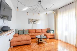 a living room with a couch and a table at Apartments Dare & Piccolo in Kaštela