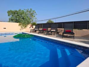 a swimming pool with chairs and a table next to it at Apartments Dare & Piccolo in Kaštela