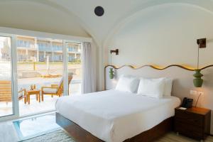 a bedroom with a large bed and a balcony at Diamond Beach By Pearl Resort in Quseir