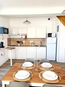 a kitchen with a wooden table with plates on it at appartement mauléon in Mauléon